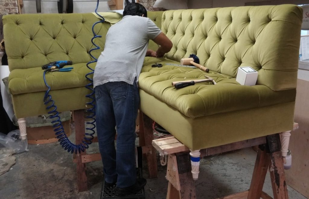 мастер ремонтирует мягкую мебель
