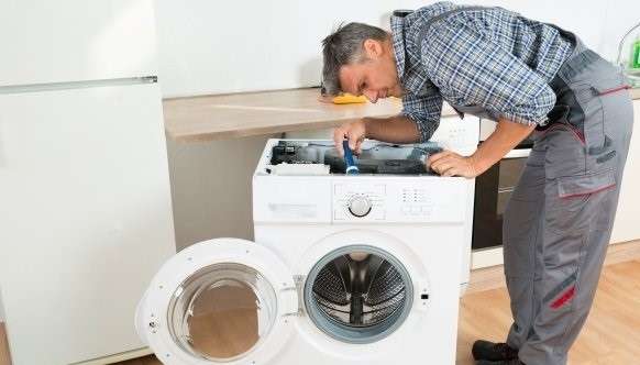 мастер ремонтирует стиральную машину